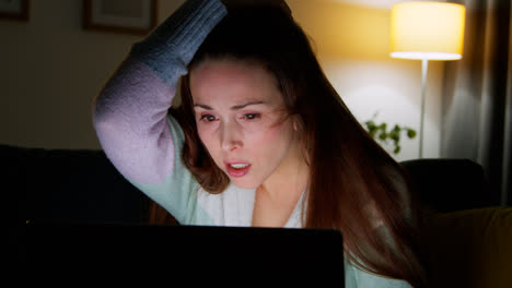 Anxious-Woman-Sitting-On-Sofa-At-Home-At-Night-Looking-At-Laptop-Concerned-About-Social-Media-Or-Bad-News-5